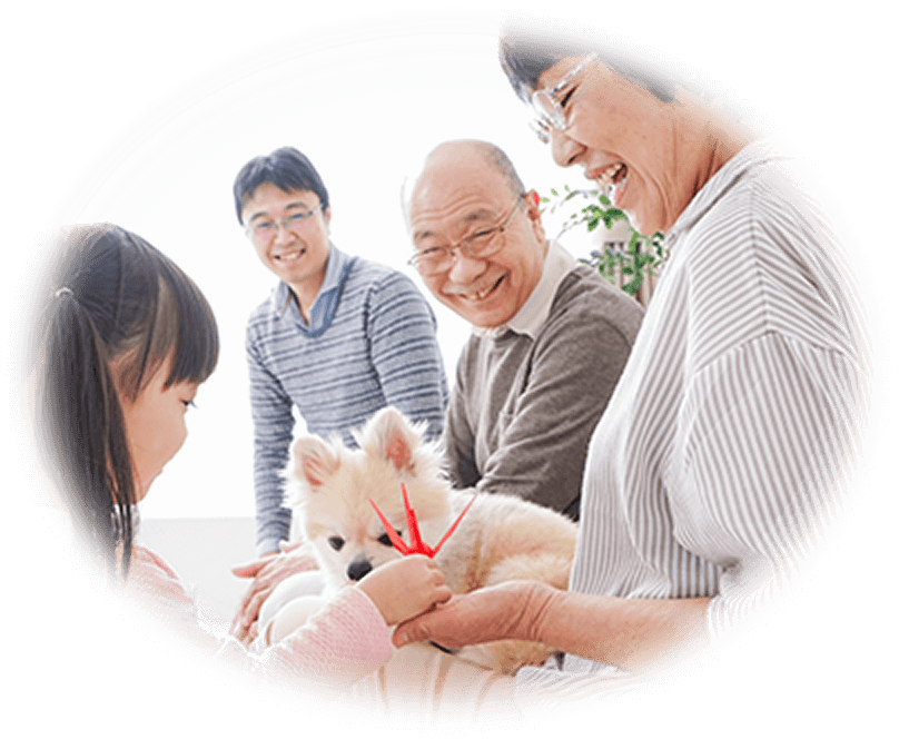 ワンちゃんと、ワンちゃんを笑顔で見ている家族