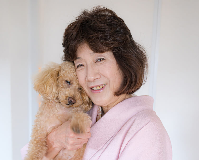 愛犬と顔をくっつけて笑っているシニア女性